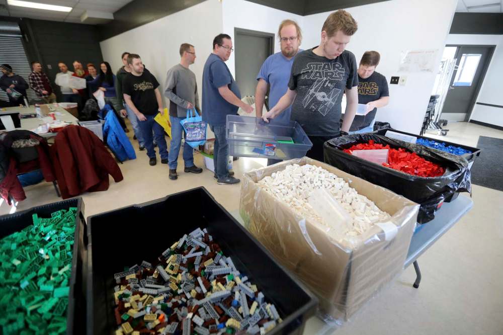 Club members divvy up 30,000 Lego pieces the block maker donated to the club over the past four years.