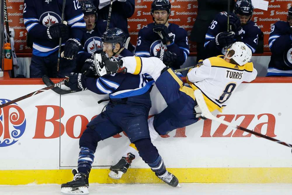 Winnipeg's Brandon Tanev takes out Kyle Turris in a physical game featuring plenty of big hits. (John Woods / The Canadian Press)