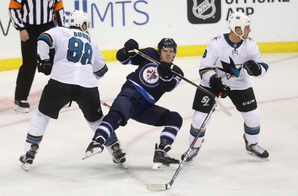 THE CANADIAN PRESS/Trevor Hagan
Winnipeg Jets' Nikolaj Ehlers gets tripped up between San Jose Sharks' Brent Burns, left, and Michael Haley Tuesday in Winnipeg. Ehlers admitted he made a mistake in the dying seconds of a tied game that allowed the Sharks to score the game-winnipeg goal with less than 4 seconds remaining on the clock.