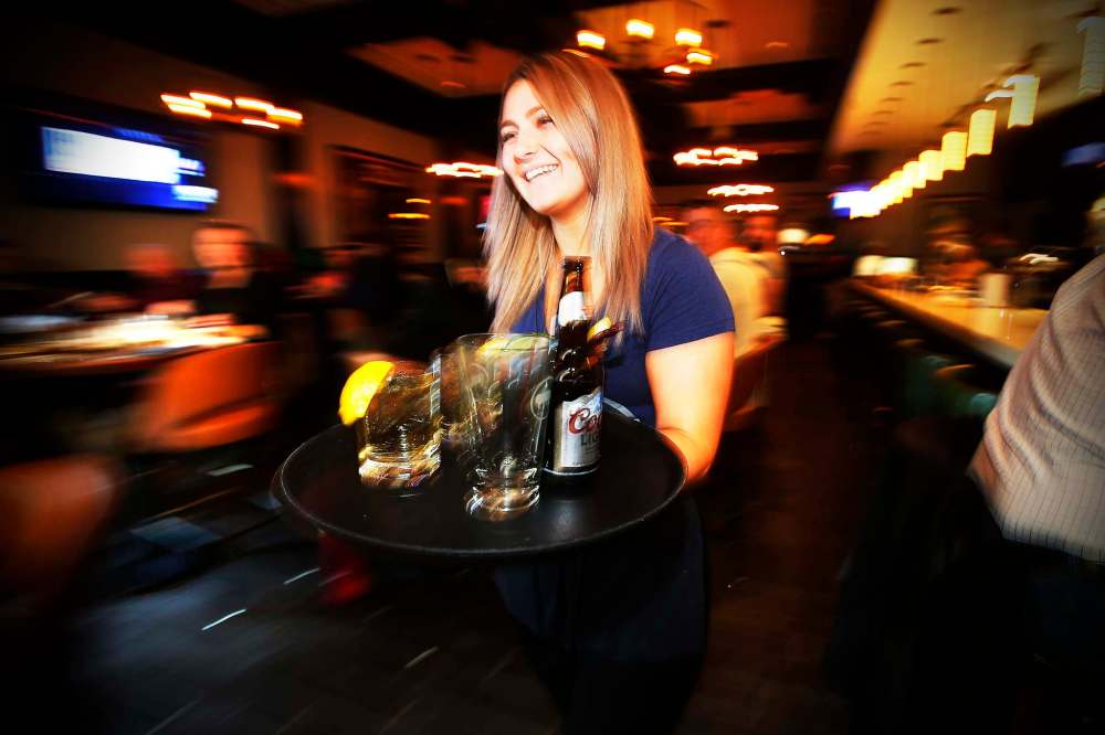 JOHN WOODS / WINNIPEG FREE PRESS
Server Tessa Grant serves up drinks during happy hour at Earls on Main Street.