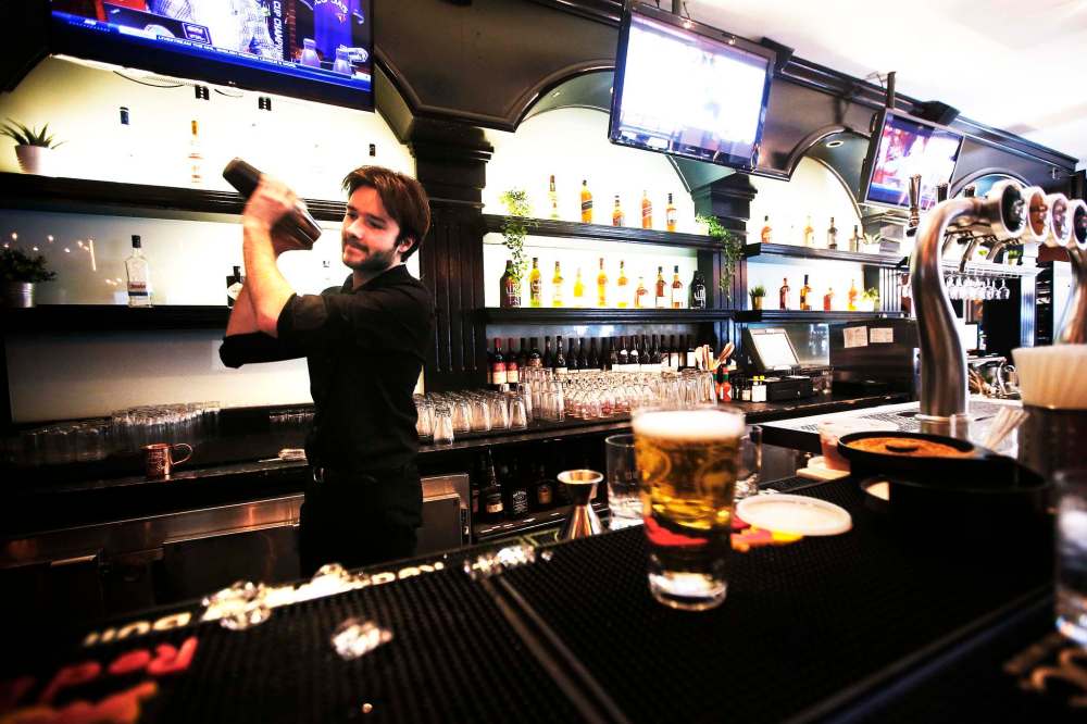 JOHN WOODS / WINNIPEG FREE PRESS
Bartender Sam Boulet mixes drinks during happy hour at Earl’s on Main Street.