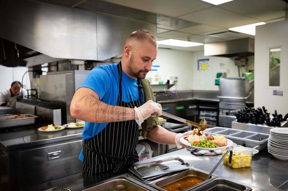 A client serves dinner at Simon House.