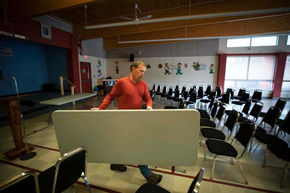 Client Joe Steeves puts out a table at a senior centre near Simon House.