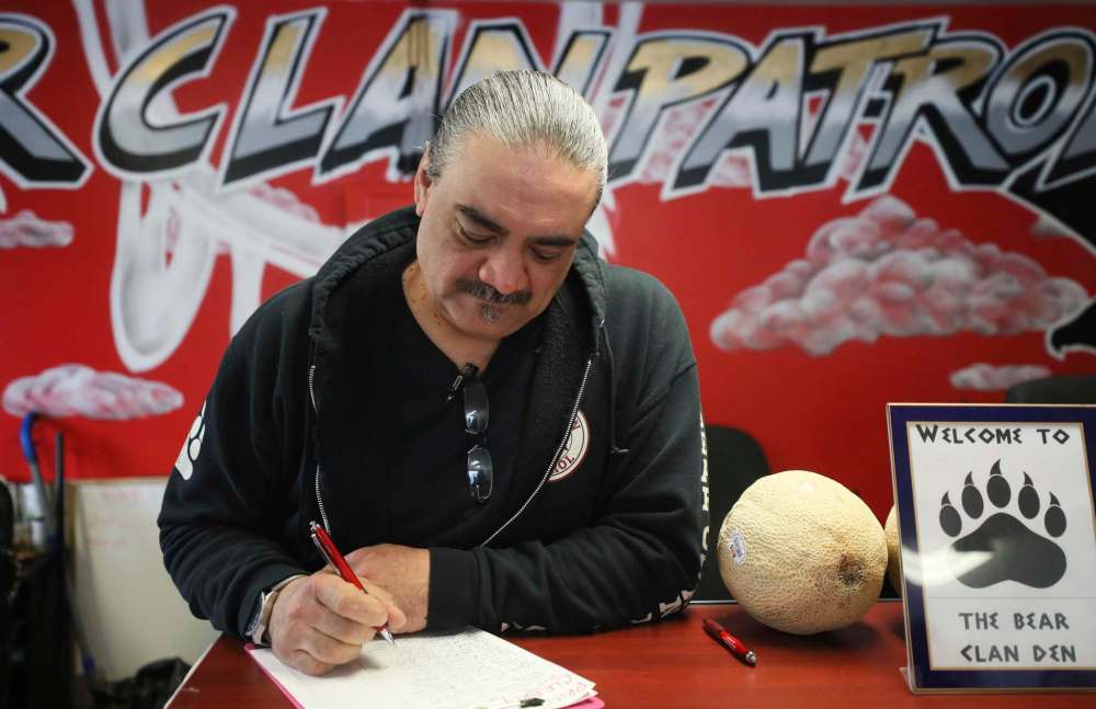 RUTH BONNEVILLE / WINNIPEG FREE PRESS
Bear Clan Patrol Executive Director, James Favel, looks over the sign-in sheet at the front desk at the clan.