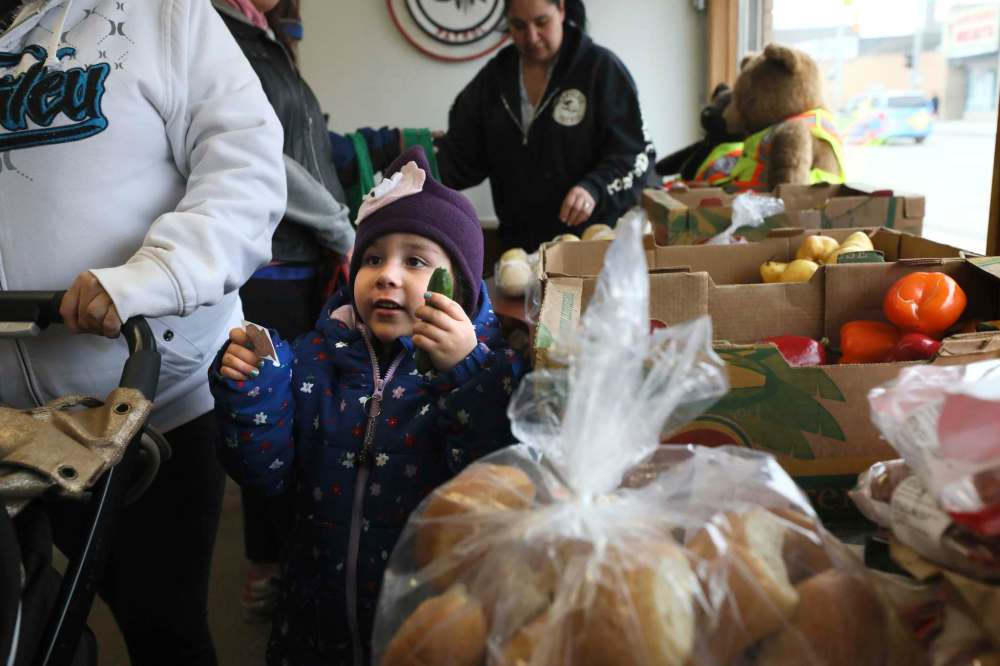 RUTH BONNEVILLE / WINNIPEG FREE PRESS
A little girl picks out a fresh little cucumber from a box of vegetables at the Clan headquarters.