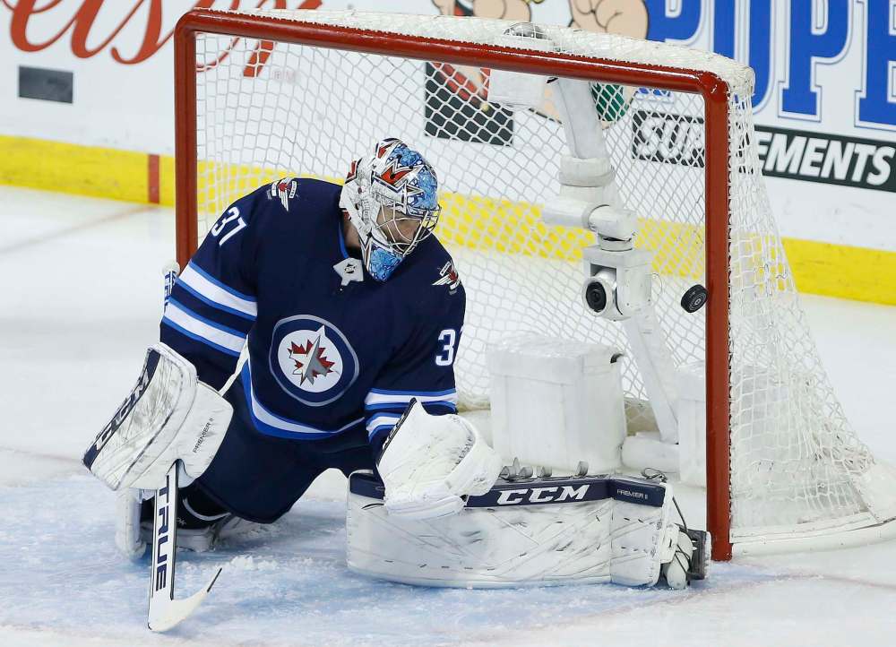 John Woods
/ The Canadian Press
Winnipeg Jets goaltender Connor Hellebuyck (37) watches as a Montreal Canadiens' shot goes off the post during first period NHL action in Winnipeg on Saturday, March 28, 2019.