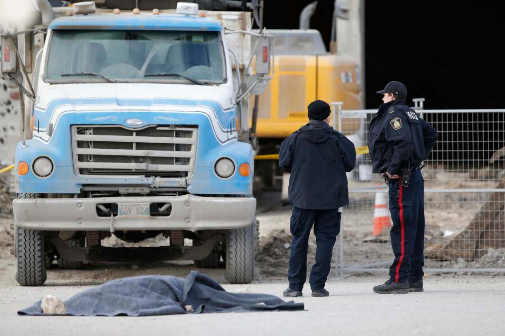 JOHN WOODS / WINNIPEG FREE PRESS
Police investigate at the scene of a fatal collision in the Garden City Shopping Centre parking lot Monday. A 57-year-old woman died after being struck by a dump truck.
