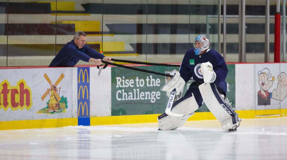 (MIKE DEAL / WINNIPEG FREE PRESS) Winnipeg Jets goaltender Connor Hellebuyck works with goaltending coach Wade Flaherty at Monday's practice. Hellebuyck says last year's playoff experience will be valuable heading into Wednesday's Game 1 against the St. Louis Blues.