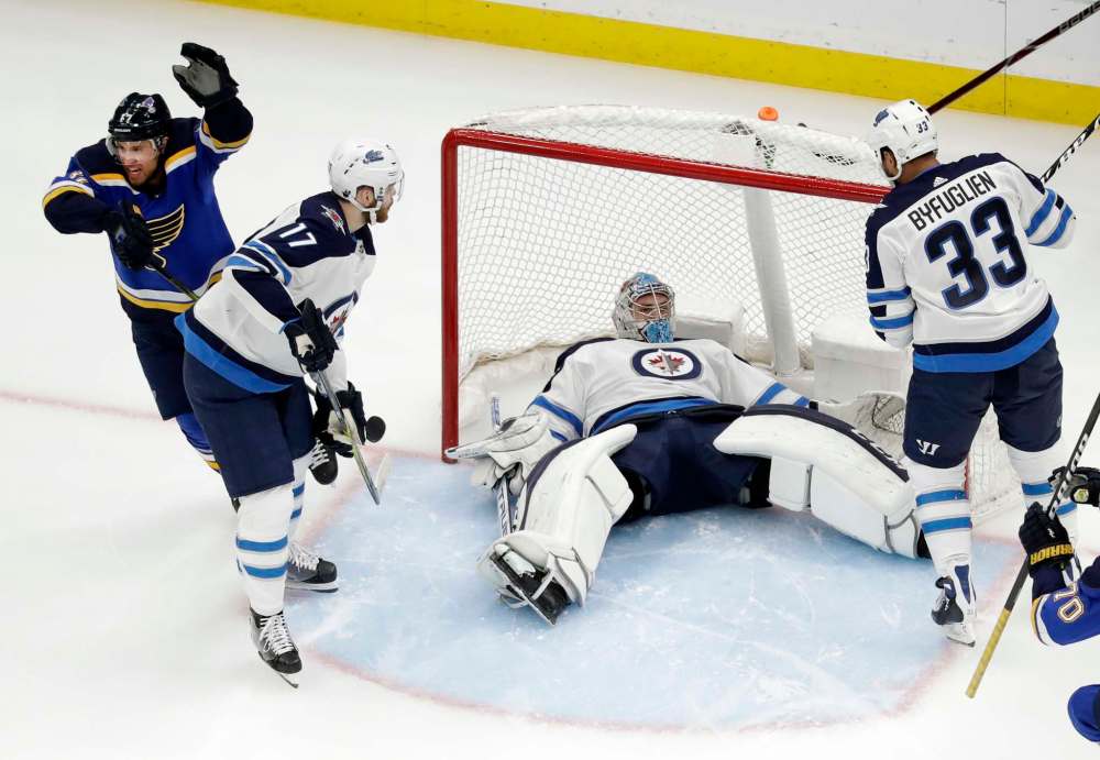St. Louis Blues' Jaden Schwartz, left, celebrates after scoring past Winnipeg Jets goaltender Connor Hellebuyck who lies in the net as Jets' Adam Lowry, second from left, and Dustin Byfuglien (33) watch during the first period in Game 6 of an NHL first-round hockey playoff series, Saturday, April 20, 2019, in St. Louis. (AP Photo/Jeff Roberson)
