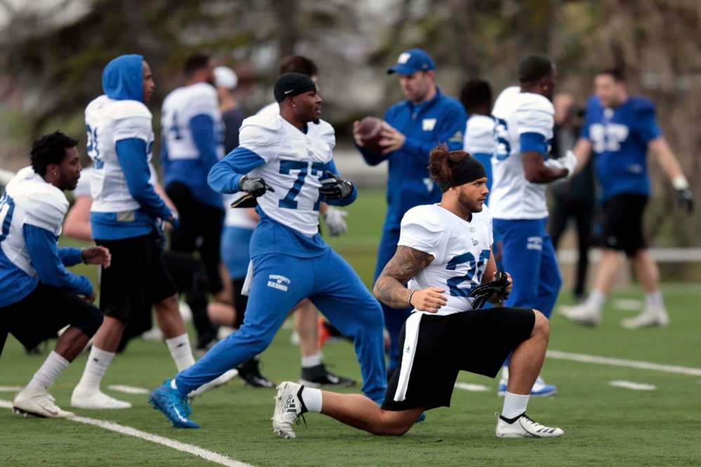 PHIL HOSSACK / WINNIPEG FREE PRESS
Bombers rookie Brady Oliveira (right) stretches out in the rain Wednesday.