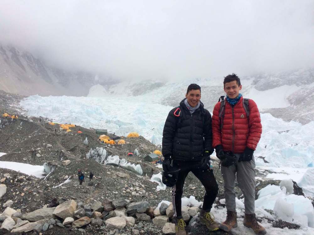 The famous rock at base camp covered in prayer flags and company posters, used as a landmark to say “I made it”.