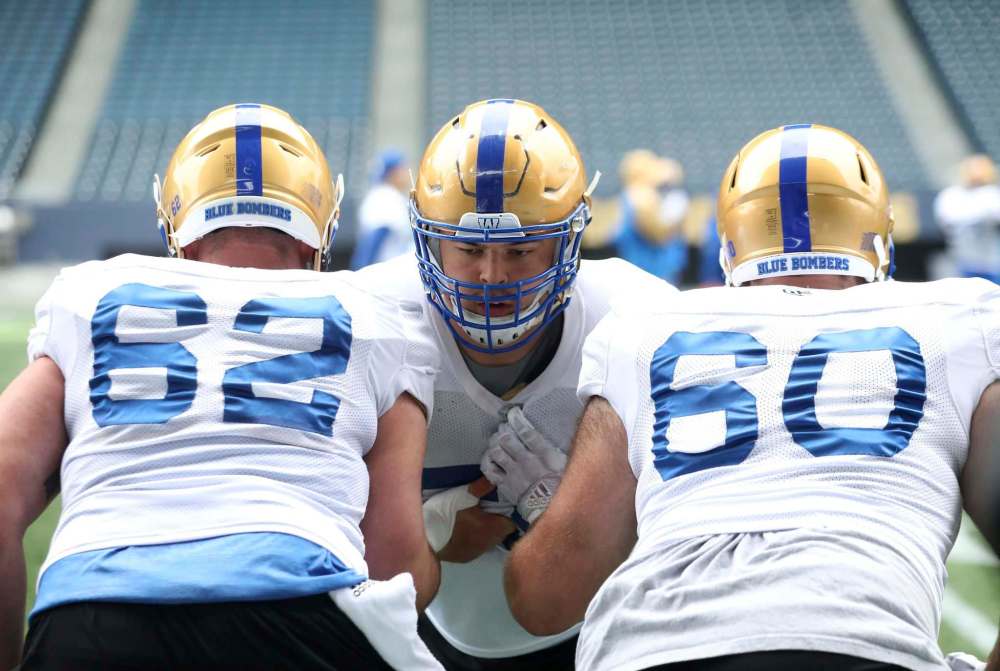RUTH BONNEVILLE / WINNIPEG FREE PRESS
Offensive lineman Michael Couture (centre) throws his weight around during Bombers training camp on Friday at IG Field. He’s hoping to nail down the starter’s role at centre.
