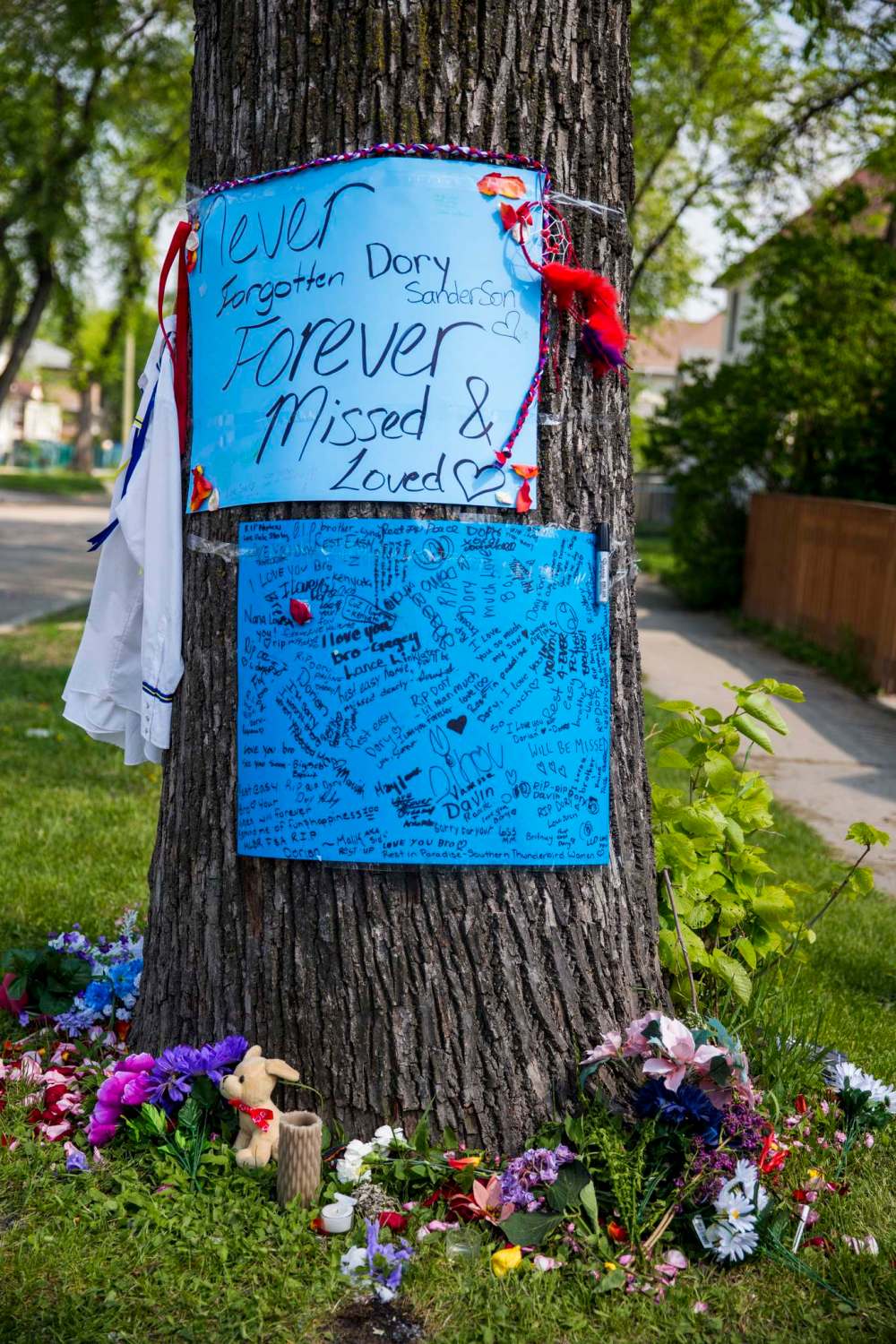 MIKAELA MACKENZIE / WINNIPEG FREE PRESS
Posters and flowers on Alfred Street in honour of Dorian Sanderson in Winnipeg on Tuesday.