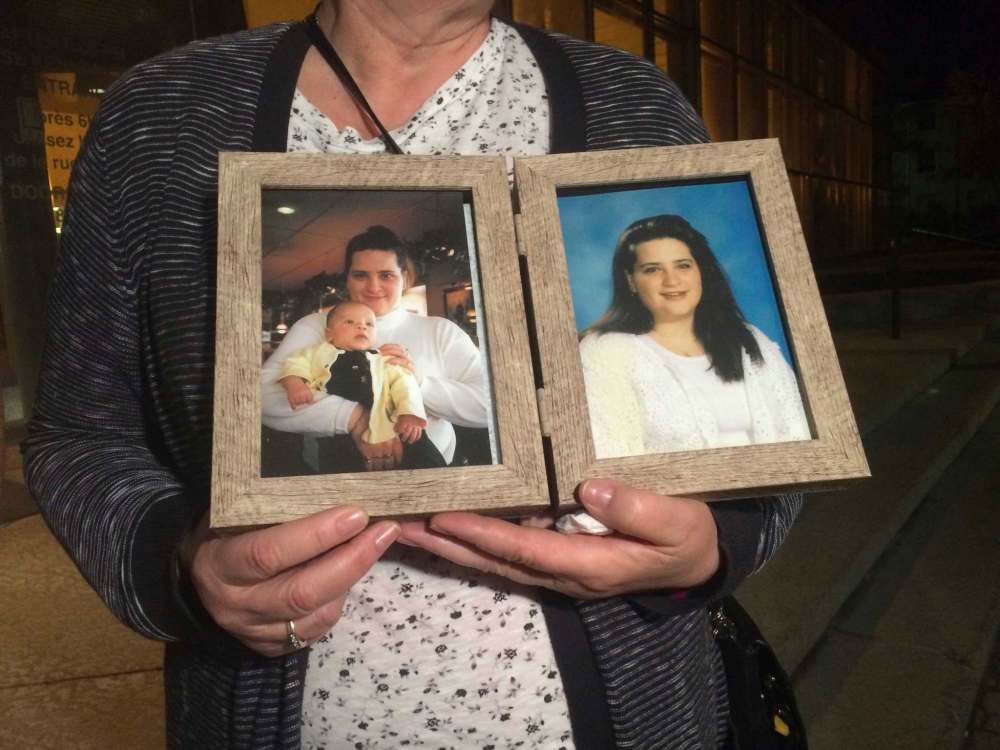Jennifer Barrett's aunt Madeline Quelle holds photos of her niece outside the Winnipeg law courts building Wednesday night. (Katie May / Winnipeg Free Press)