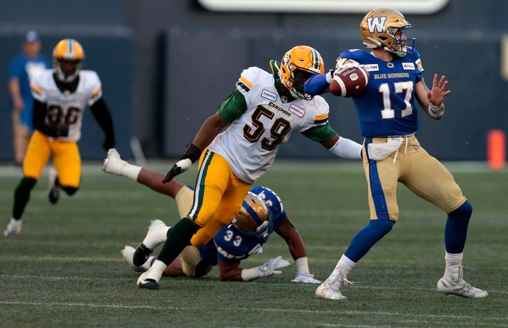 PHIL HOSSACK / WINNIPEG FREE PRESS
Winnipeg Blue Bombers QB Chris Streveler takes aim despite pressure from Edmonton Eskimos' Darious Jackson at Investor's Group Field Friday.