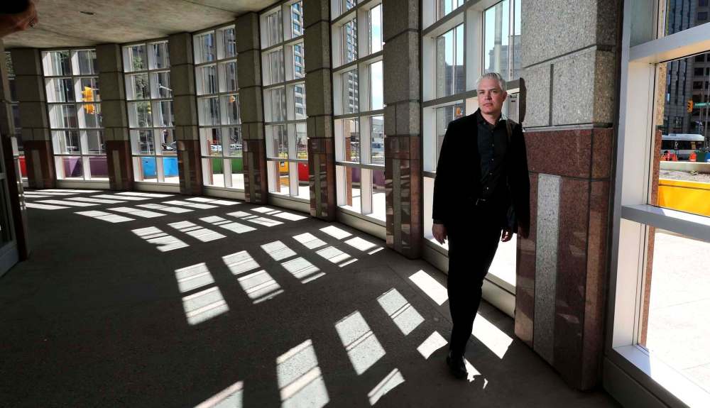RUTH BONNEVILLE / WINNIPEG FREE PRESS
Architect Michael Banman stands in the glassed-in walkway on the ground floor of 201 Portage Ave. Smokers use the space when it’s raining or cold. Harvard Developments wants it to become part of a unit that can be leased.