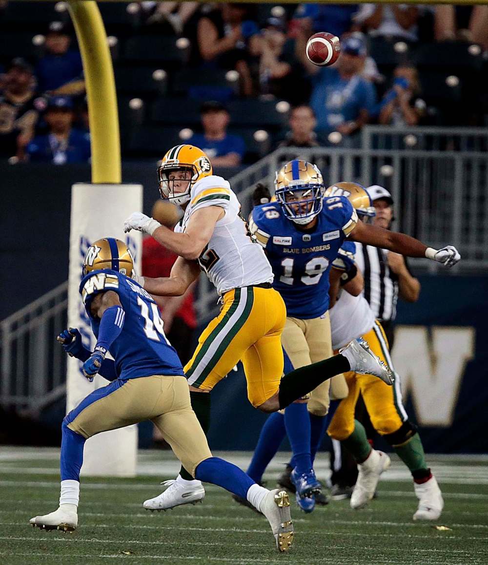 PHIL HOSSACK / WINNIPEG FREE PRESS - Edmonton Eskimo #82 Greg Ellingson looks back over his shoulder for the pass attempt while evading coverage from Winnipeg Blue Bombers #14 Marcus Sayles and #19 Kyrie Wilsonl in the 2nd half.