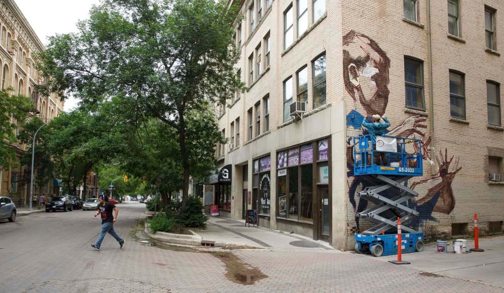 MIKE DEAL / WINNIPEG FREE PRESS
Saskatchewan artist Jarus uses a scissor lift to work on a mural just off of Albert Street.