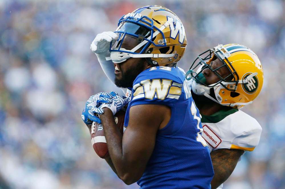 THE CANADIAN PRESS/John Woods
Winnipeg Blue Bombers' Chris Matthews can't hang onto the pass as Edmonton Eskimos' Forrest Hightower gets his hand on Matthews' mask during CFL action in Winnipeg Thursday. Matthews missed most of training camp and all of the pre-season due to an undisclosed injury.