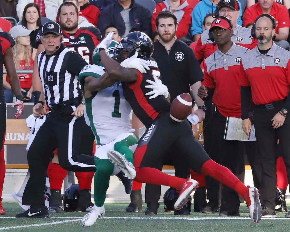 Saskatchewan Roughriders wide receiver Shaq Evans loses the ball as he collides with Chris Randle last month in Ottawa. (Fred Chartrand / Canadian Press files)