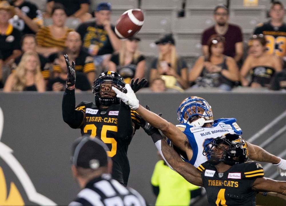 PETER POWER / THE CANADIAN PRESS FILES
Tiger-Cats defensive back Jumal Rolle (left) making an interception on a pass intended for Bombers wide receiver Kenny Lawler in Friday’s game.