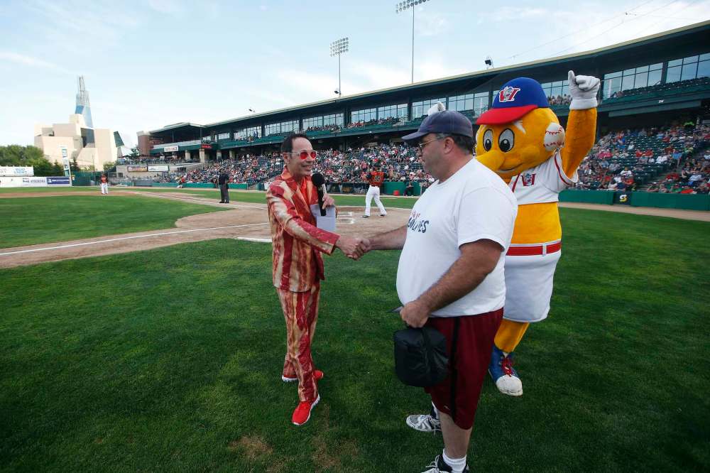 Chase (left) quizzes contest winner Chris on swine-related questions. (John Woods / Winnipeg Free Press)