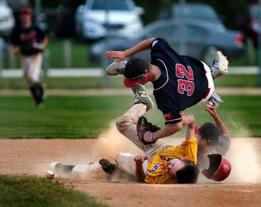 PHIL HOSSACK / WINNIPEG FREE PRESS
St Boniface baserunner Kyle Becker slams his head into the gravel at second base in a three-way collision with Elmwood’s Owen Harms (top) and Zach Delaquis.