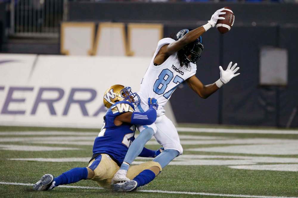 John Woods / The Canadian Press files
Blue Bombers defensive back Chandler Fenner (left, grabbing Toronto’s Derel Walker during Friday’s game) was spied wearing oven mitts at Monday’s practice.