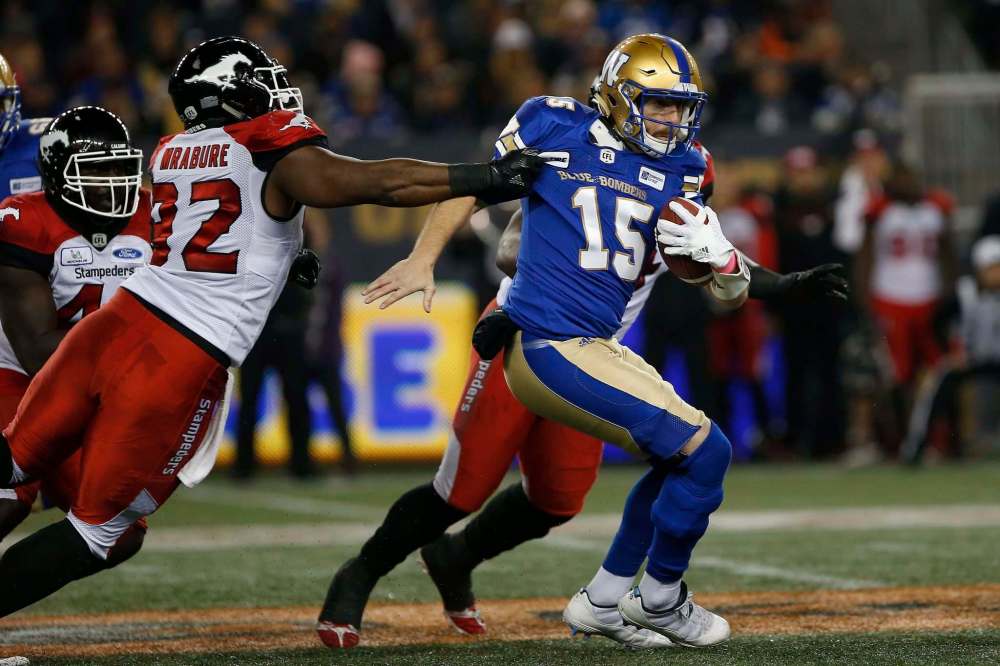 John Woods / The Canadian Press files
Blue Bombers quarterback Matt Nichols (right, being grabbed by Calgary’s Ese Mrabure) says the Stamps are ‘good from the top down.