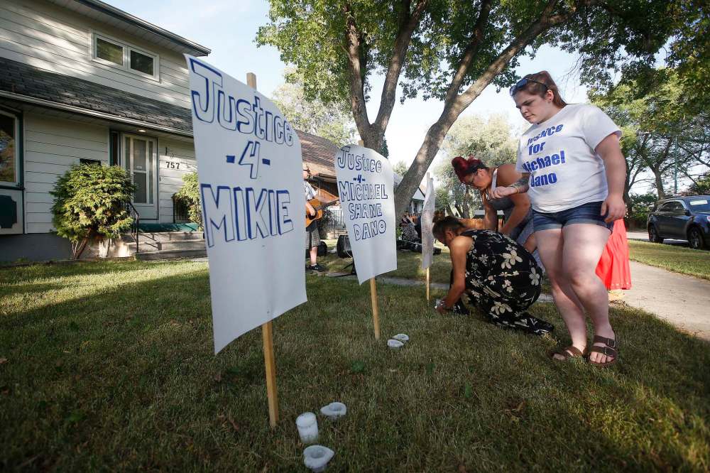 JOHN WOODS / WINNIPEG FREE PRESS
Women light candles during a vigil Tuesday in front of 757 Chalmers Street East.