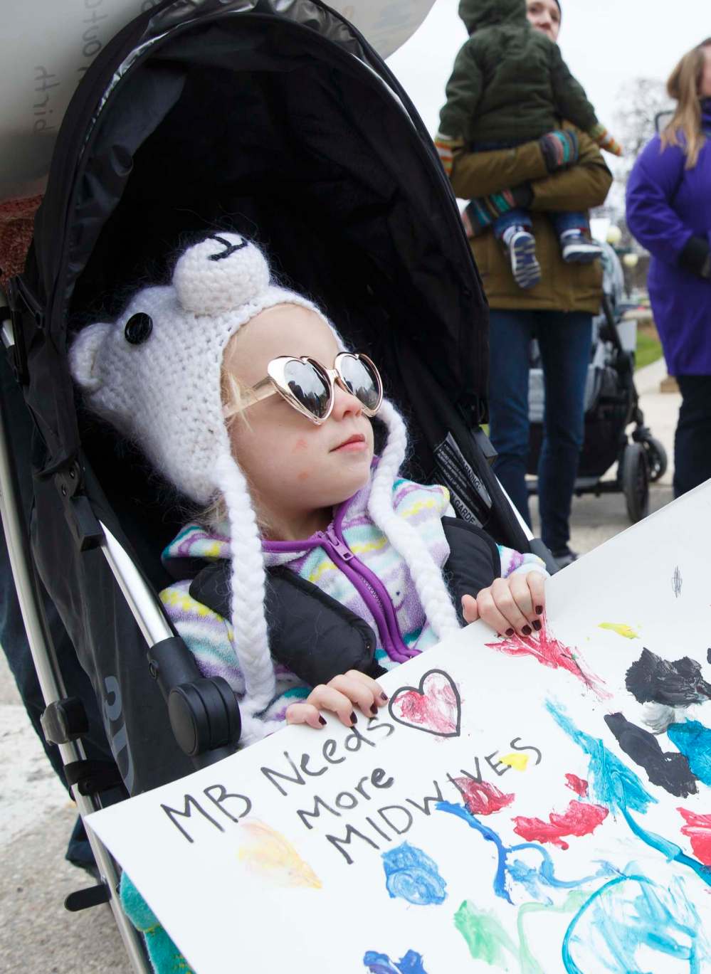 MIKE DEAL / WINNIPEG FREE PRESS FILES
Poppy Haywood, 2, holds a sign during a rally at the Manitoba Legislative building in May calling for more midwivery positions in the province.
