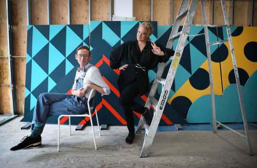 Wall-to-Wall Mural & Culture Festival&rsquo;s Directors and Curators, Chloe Chafe and Andrew Eastman, in front of art work painted on boards that will be pieced together and become a large mural placed over a construction area next to the Fortune block. (Ruth Bonneville / Winnipeg Free Press)