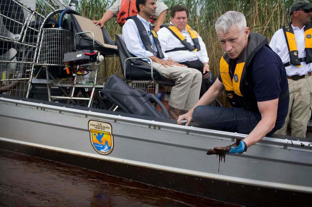 Cooper, right, inspects the oil spill during a tour with Louisiana Gov. Bobby Jindal, background left, of the contaminated areas in Blind Bay, La. in 2010. (Shaul Schwarz / CNN / Associated Press files)