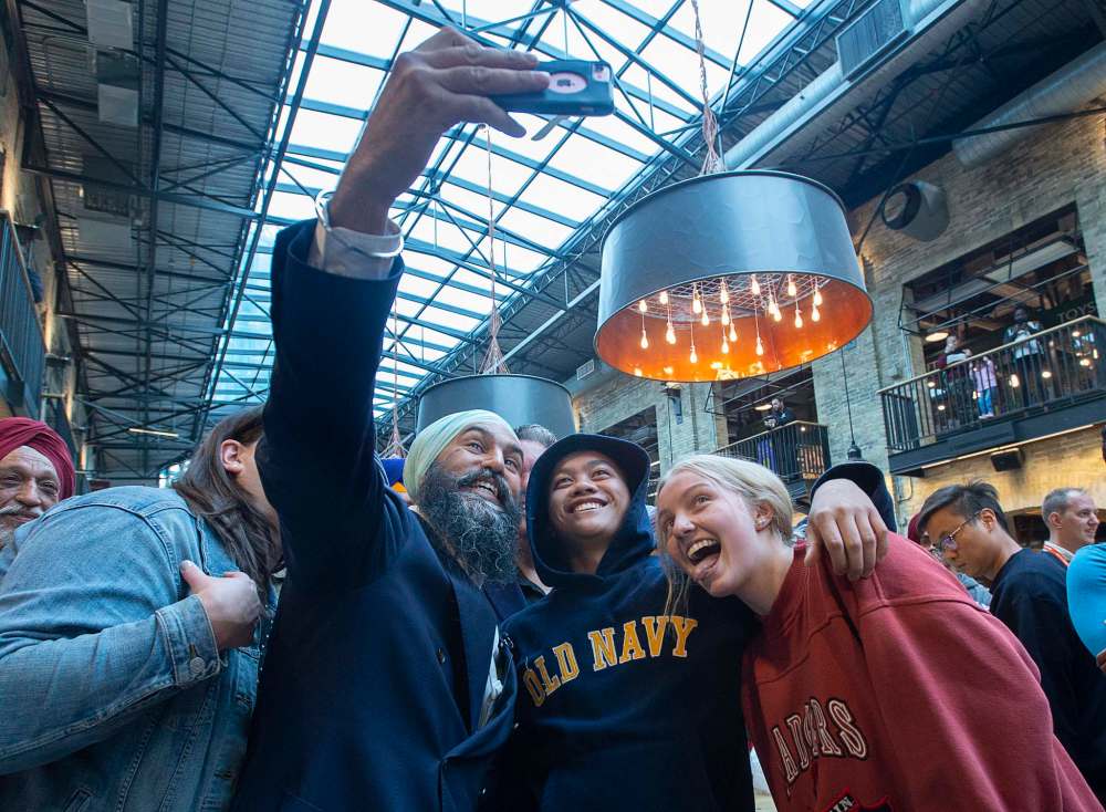 Federal NDP Leader Jagmeet Singh poses for a photo with young supporters during a campaign stop at The Forks Market in Winnipeg on Tuesday. (Andrew Vaughan / The Canadian Press)