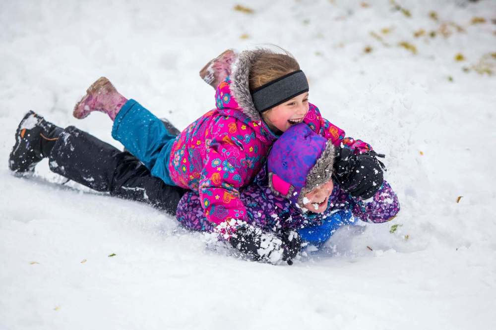 MIKAELA MACKENZIE / WINNIPEG FREE PRESS
Nava Davidson, six (top), and Kara Davidson, eight, toboggan on a snowy fall day at Omand's Creek on Saturday.