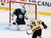 Laurent Brossoit goes down, Jake Guentzel aims high. (Fred Greenslade / The Canadian Press)