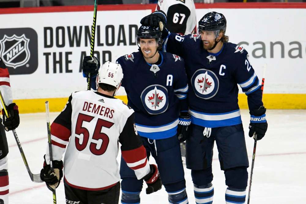 Mark Scheifele celebrates his goal with Blake Wheeler during the first period Tuesday. (Fred Greenslade / The Canadian Press)