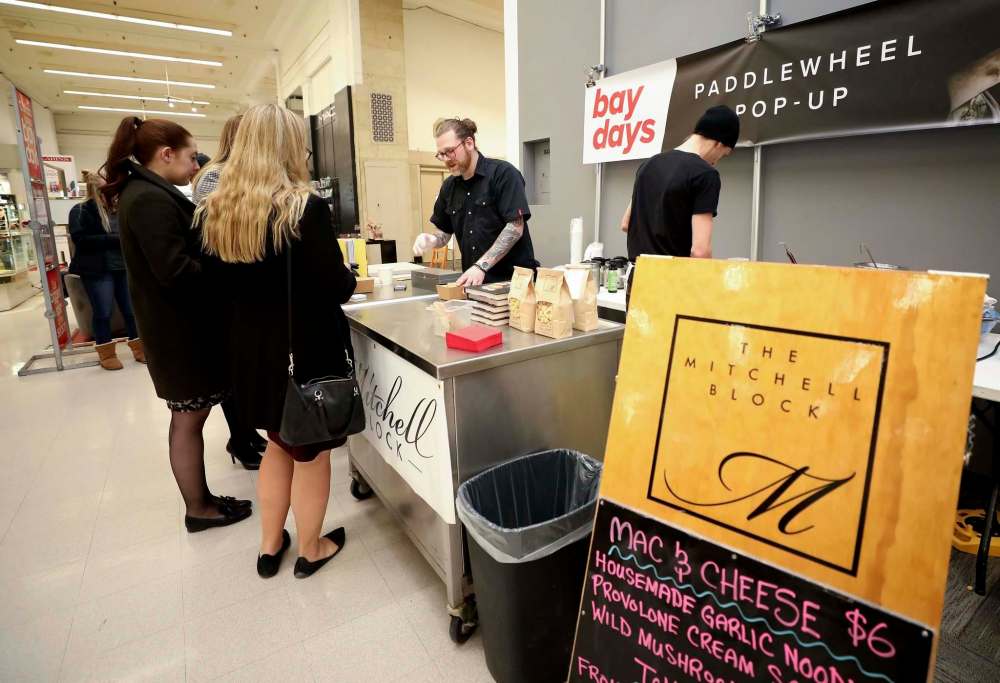 Photos by RUTH BONNEVILLE / WINNIPEG FREE PRESS
Mitchell Block chef Rob Craig (top, from centre) and owner and head chef Sean McKay, prepare and serve lunch at the Bay’s pop-up restaurant on Thursday.