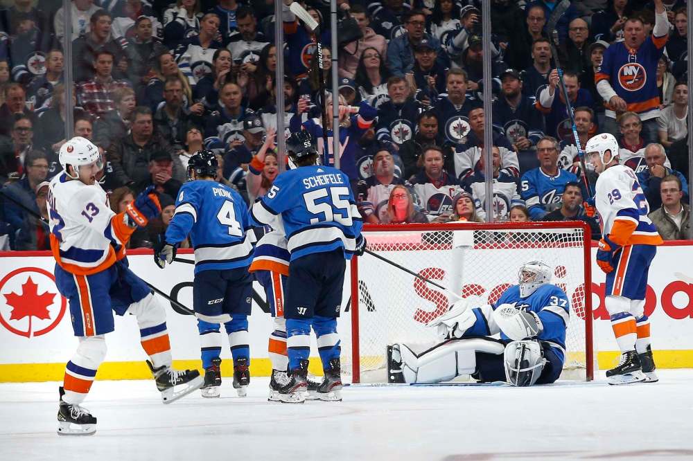THE CANADIAN PRESS/John Woods
New York Islanders' Mathew Barzal celebrates his goal against the Winnipeg Jets as goaltender Connor Hellebuyck looks on during the second period in Winnipeg on Thursday.