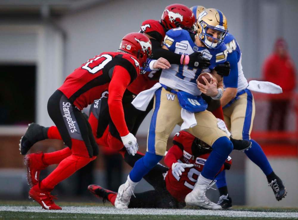 THE CANADIAN PRESS/Jeff McIntosh
Winnipeg Blue Bombers quarterback Chris Streveler, centre, is swarmed by Calgary Stampeders players during the first half in Calgary, Saturday.