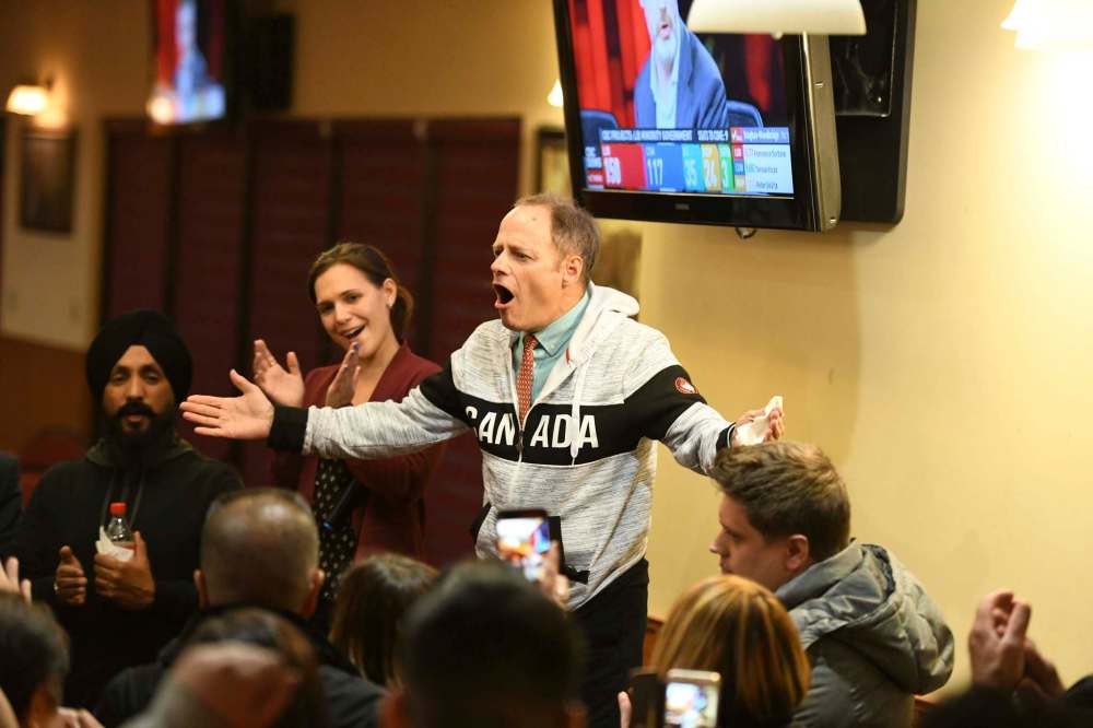 Kevin Lamoureux, and his daughter Cindy Lamoureux, MLA for Tyndall Park, celebrate with enthusiastic supporters at the Punjab Banquet Hall next to the candidate's Winnipeg constituency office. (Mike Sudoma / Winnipeg Free Press)