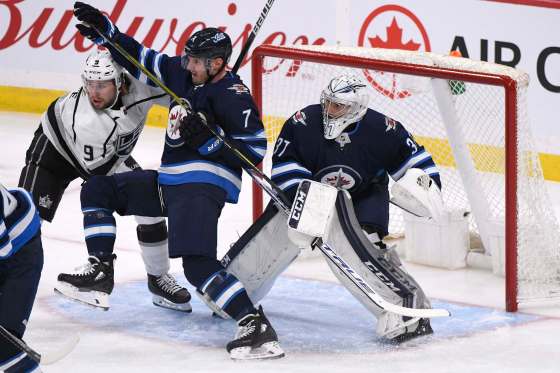 THE CANADIAN PRESS/Fred GreensladeWinnipeg Jets' Dmitry Kulikov and Los Angeles Kings' Adrian Kempe fight for position in front of goaltender Connor Hellebuyck in the first period.