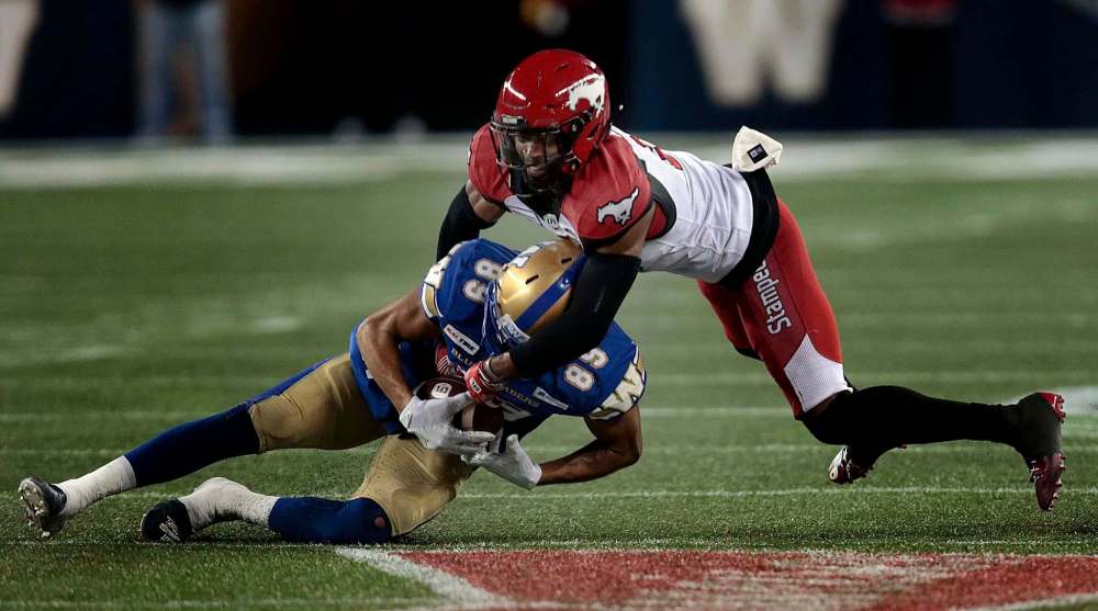 Winnipeg Blue Bombers #89 Kenny Lawler clings to the reception as he's taken down by Calgary Stampeders #8 DaShaun Amos at IG Field on Oct. 25. (Phil Hossack / Winnipeg Free Press files)