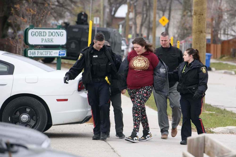 Mike Sudoma / Winnipeg Free Press
A woman is taken out of a house on Pacific Avenue Thursday morning after a police standoff.