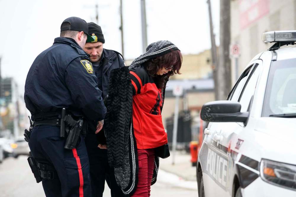 Mike Sudoma / Winnipeg Free Press
A female suspect is taken into a Winnipeg police cruiser after being involved in a standoff with the Winnipeg police Thursday.