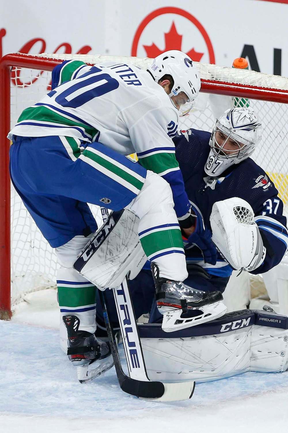 JOHN WOODS / THE CANADIAN PRESS
Canucks forward Brandon Sutter barges into Jets goalie Connor Hellebuyck’s crease. Hellebuyck is starting to find his form this season.