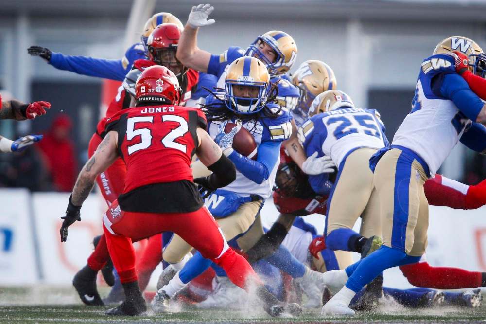 JEFF MCINTOSH / THE CANADIAN PRESS
Winnipeg Blue Bombers' Janarion Grant, centre, runs the ball as Calgary Stampeders' Riley Jones closes in.