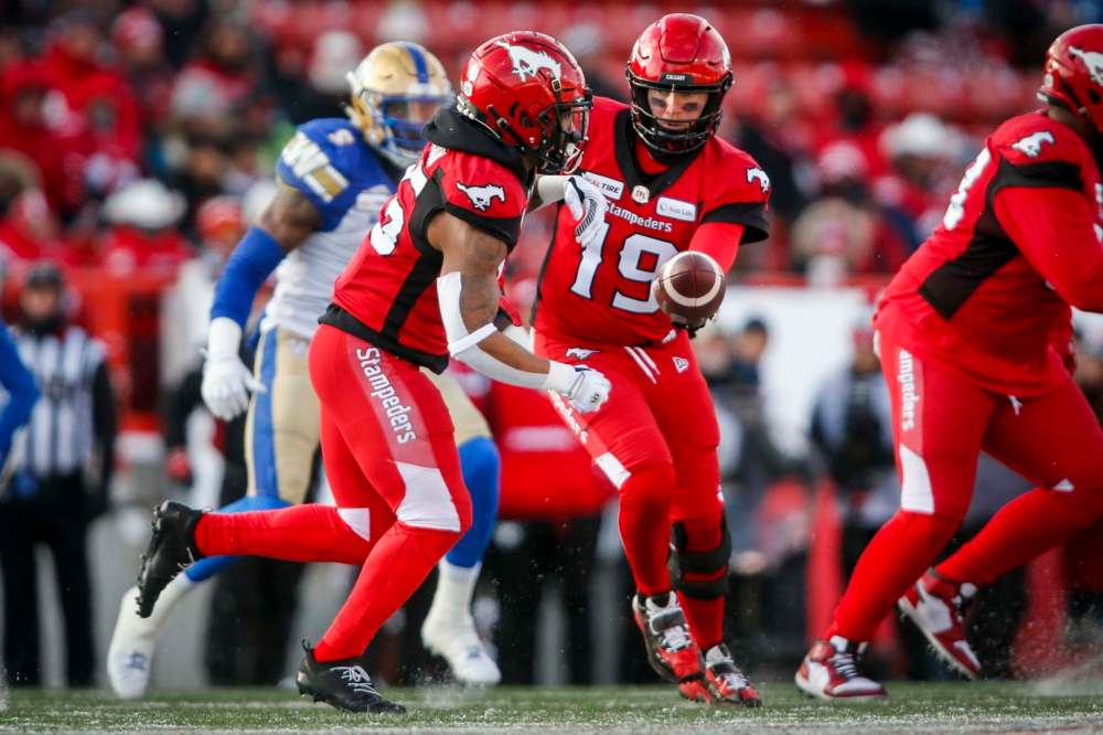 JEFF MCINTOSH / THE CANADIAN PRESS
Calgary Stampeders quarterback Bo Levi Mitchell, right, hands the ball off to teammate Don Jackson.