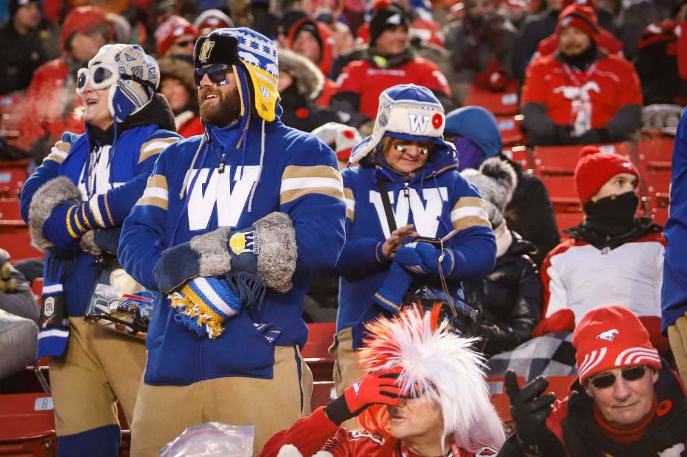JEFF MCINTOSH / THE CANADIAN PRESS
Winnipeg Blue Bombers fans cheer their team as Calgary Stampeders fans react.