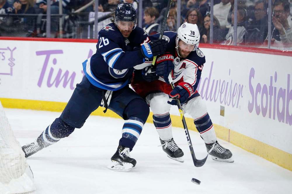 John Woods / The Canadian Press
Jets forward Blake Wheeler (left) and Blue Jackets forward Boone Jenner chase down a loose puck during second-period NHL action in Winnipeg on Saturday.